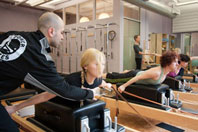 Power Pilates instructor with students
